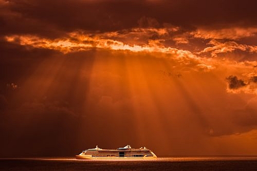 Sunshine illuminates a cruise ship at sea.