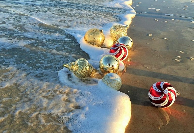 Christmas ornaments touched by waves on a beach